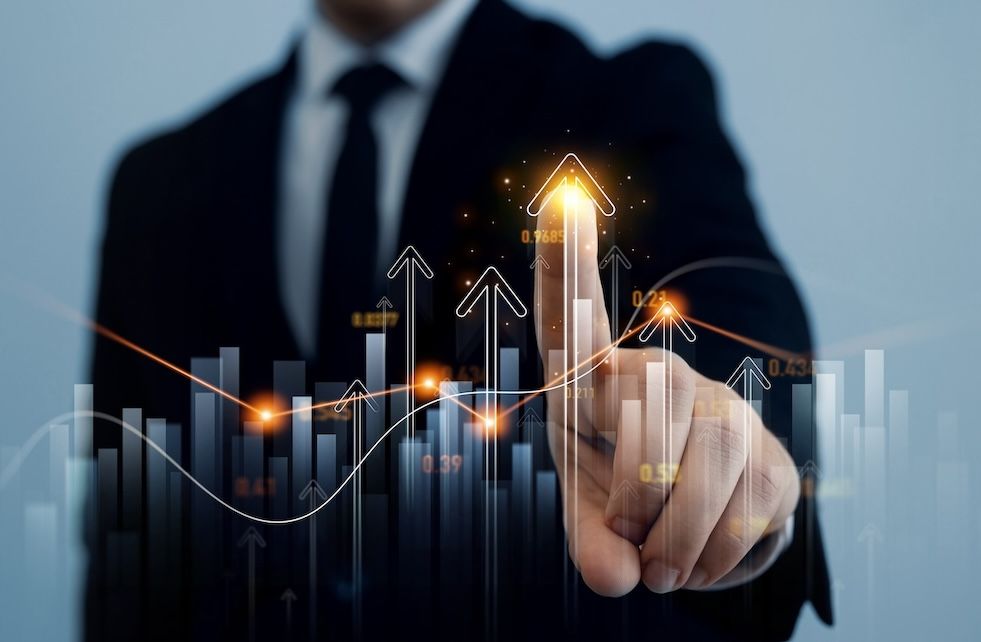 Businessman in suit touching a glowing upward arrow on a virtual financial graph, symbolizing growth and success.